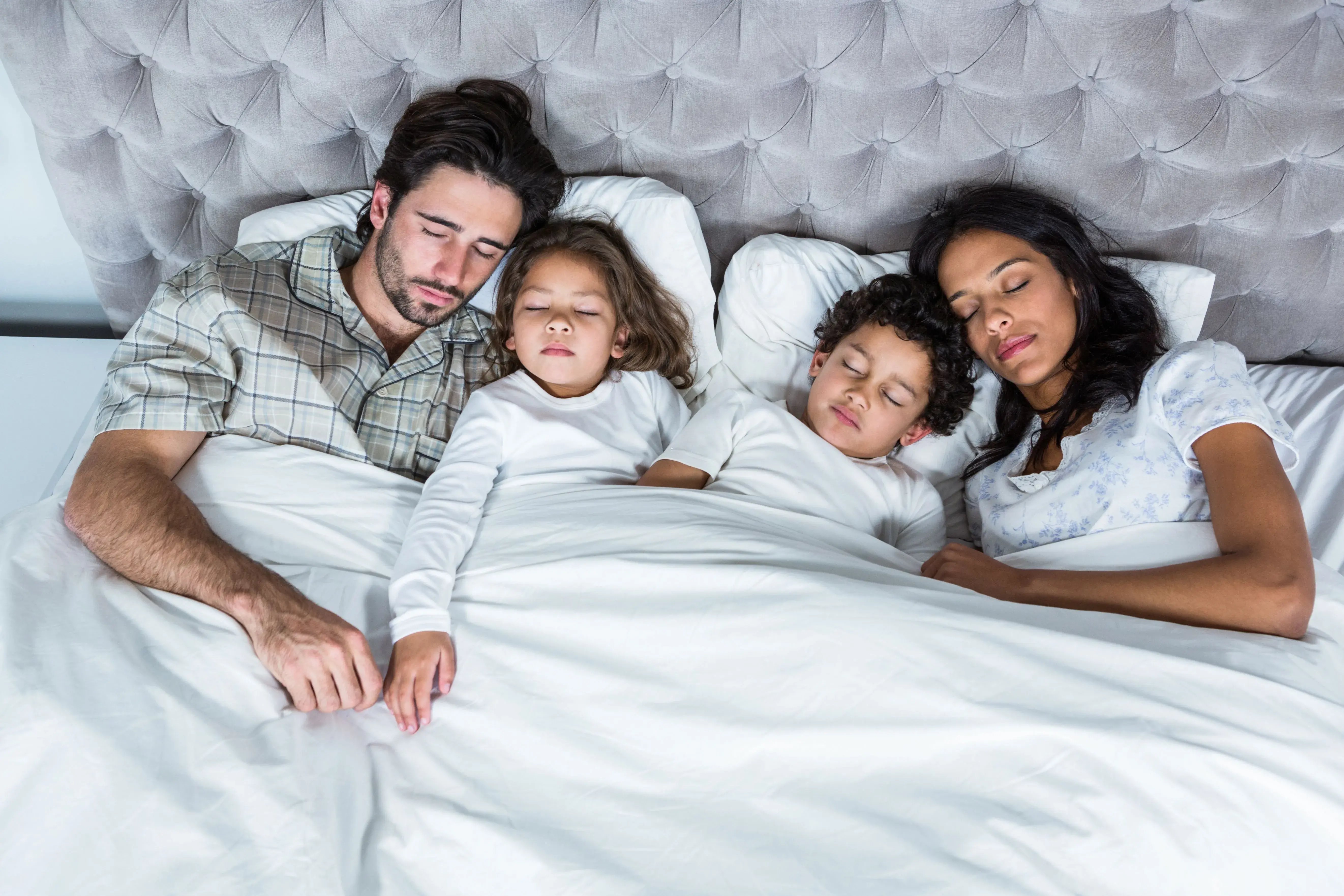 family sleeping in bed