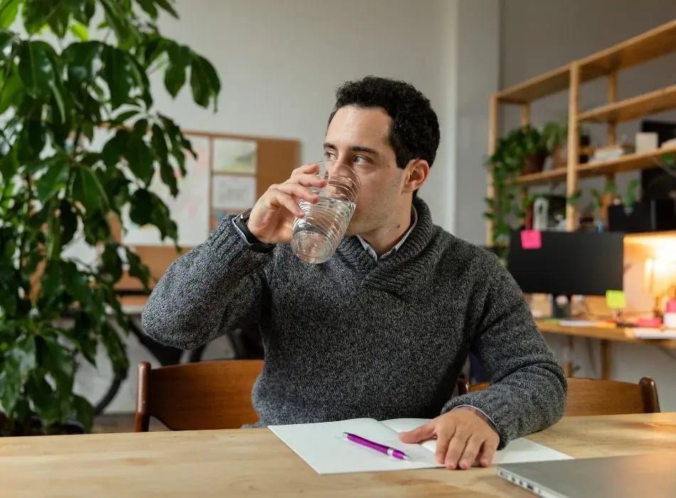 man drinking a glass of water