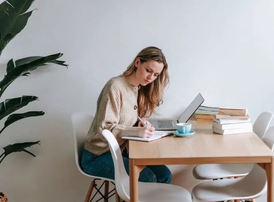 woman at desk writing plans