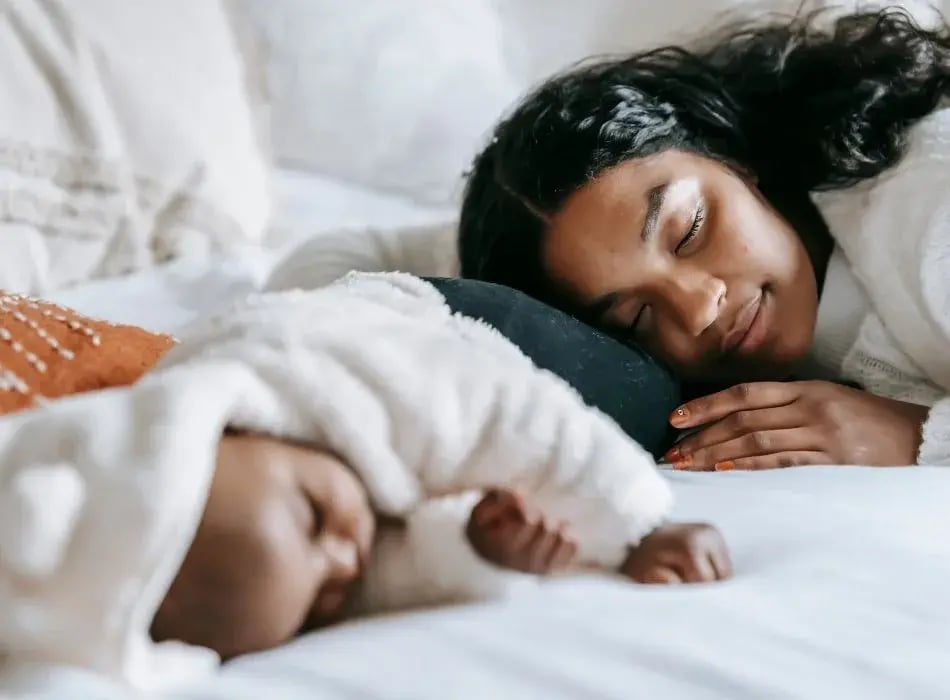 mom sleeping next to baby