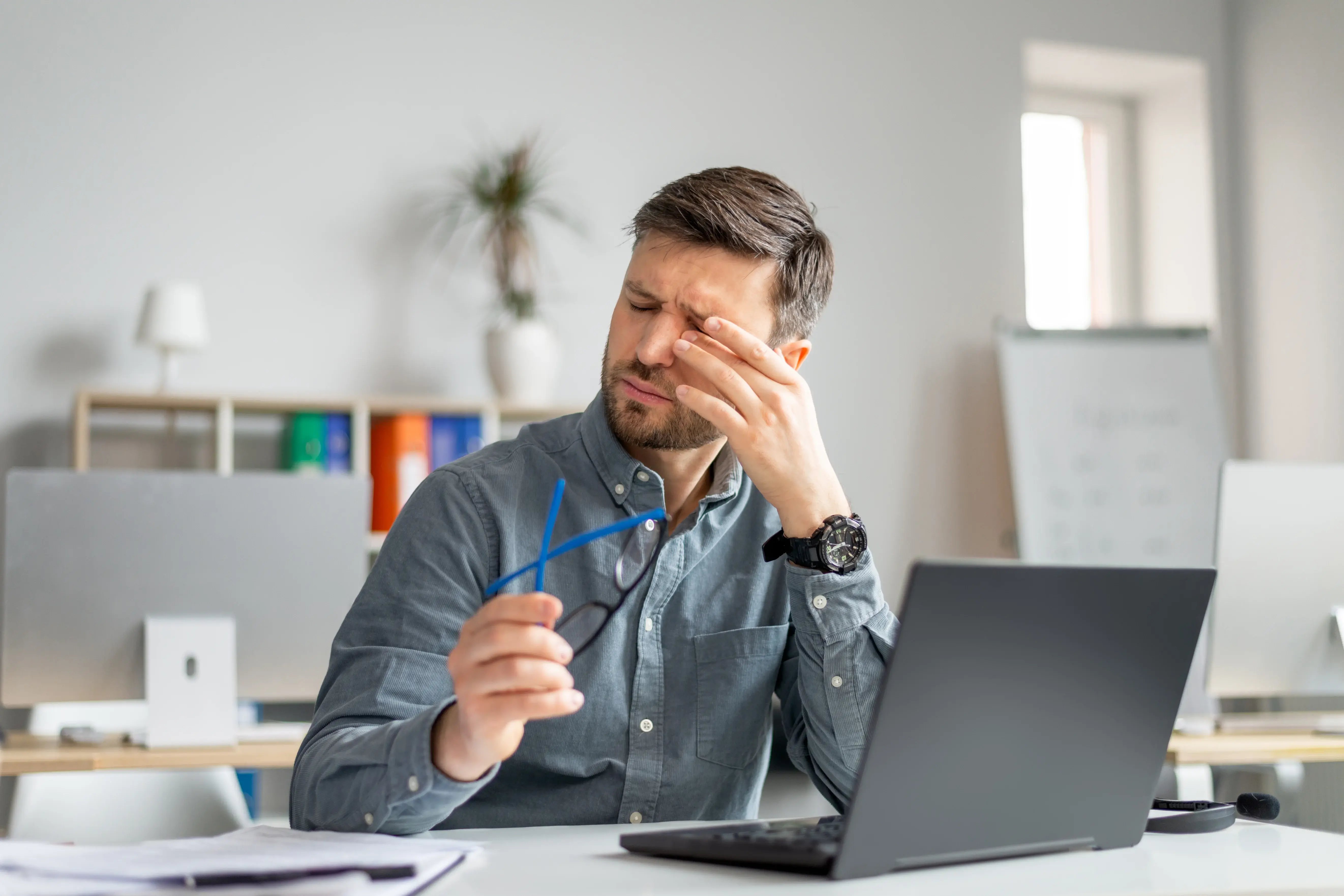 man at desk with eye strain